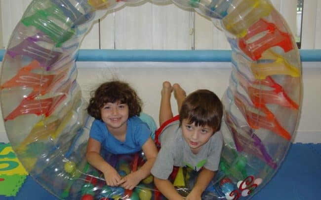 kids sitting in tube toy